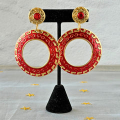 Vintage 1980s red enamel and gold‑tone circle dangle post earrings with pressed scroll and Greek key design on original Impressions card.