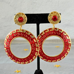 Vintage 1980s red enamel and gold‑tone circle dangle post earrings with pressed scroll and Greek key design on original Impressions card.