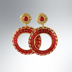 Vintage 1980s red enamel and gold‑tone circle dangle post earrings with pressed scroll and Greek key design on original Impressions card.