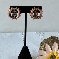 Vintage Renoir copper and black modernist clip‑on earrings with circular bead rim and sculptural center design, signed Renoir.
