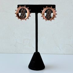 Vintage Renoir copper and black modernist clip‑on earrings with circular bead rim and sculptural center design, signed Renoir.
