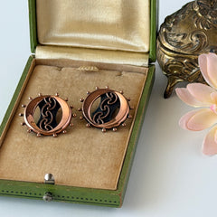 Vintage Renoir copper and black modernist clip‑on earrings with circular bead rim and sculptural center design, signed Renoir.