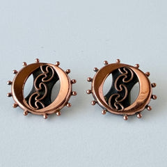 Vintage Renoir copper and black modernist clip‑on earrings with circular bead rim and sculptural center design, signed Renoir.
