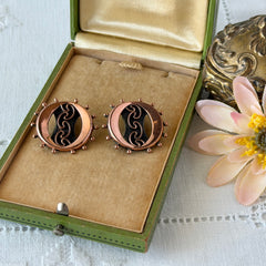 Vintage Renoir copper and black modernist clip‑on earrings with circular bead rim and sculptural center design, signed Renoir.