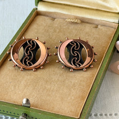 Vintage Renoir copper and black modernist clip‑on earrings with circular bead rim and sculptural center design, signed Renoir.