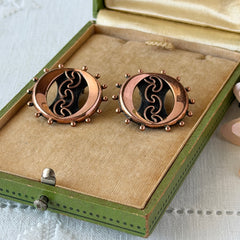 Vintage Renoir copper and black modernist clip‑on earrings with circular bead rim and sculptural center design, signed Renoir.