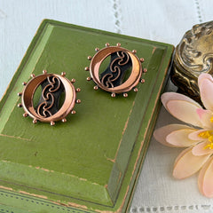 Vintage Renoir copper and black modernist clip‑on earrings with circular bead rim and sculptural center design, signed Renoir.