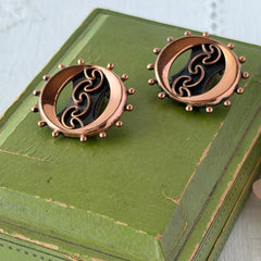 Vintage Renoir copper and black modernist clip‑on earrings with circular bead rim and sculptural center design, signed Renoir.