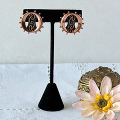Vintage Renoir copper and black modernist clip‑on earrings with circular bead rim and sculptural center design, signed Renoir.