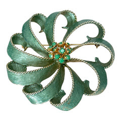 Vintage 1960s floral brooch with light green enamel ribbon petals, gold tone rope edges, and rhinestone center.