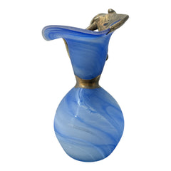 Signed Romanian handblown art glass vase from the 1990s featuring swirling blue glass and sculptural bronze overlay with organic vine-like forms. The vase has a flared top, narrow base, and an undeciphered artist’s signature etched into the glass. A collectible decorative piece in very good vintage condition.