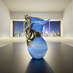 Signed Romanian handblown art glass vase from the 1990s featuring swirling blue glass and sculptural bronze overlay with organic vine-like forms. The vase has a flared top, narrow base, and an undeciphered artist’s signature etched into the glass. A collectible decorative piece in very good vintage condition.