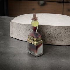 Vintage Romanian art glass perfume bottle with a plum and yellow frosted body, square base, and rounded neck, adorned with bronze wire and a sculptural stopper featuring a translucent yellow-green bead and plum-toned top.