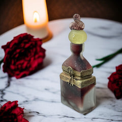 Vintage Romanian art glass perfume bottle with a plum and yellow frosted body, square base, and rounded neck, adorned with bronze wire and a sculptural stopper featuring a translucent yellow-green bead and plum-toned top.