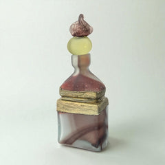 Vintage Romanian art glass perfume bottle with a plum and yellow frosted body, square base, and rounded neck, adorned with bronze wire and a sculptural stopper featuring a translucent yellow-green bead and plum-toned top.