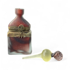 Vintage Romanian art glass perfume bottle with a plum and yellow frosted body, square base, and rounded neck, adorned with bronze wire and a sculptural stopper featuring a translucent yellow-green bead and plum-toned top.