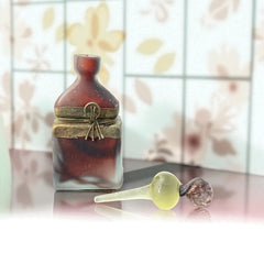 Vintage Romanian art glass perfume bottle with a plum and yellow frosted body, square base, and rounded neck, adorned with bronze wire and a sculptural stopper featuring a translucent yellow-green bead and plum-toned top.