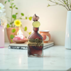Vintage Romanian art glass perfume bottle with a plum and yellow frosted body, square base, and rounded neck, adorned with bronze wire and a sculptural stopper featuring a translucent yellow-green bead and plum-toned top.