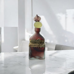 Vintage Romanian art glass perfume bottle with a plum and yellow frosted body, square base, and rounded neck, adorned with bronze wire and a sculptural stopper featuring a translucent yellow-green bead and plum-toned top.