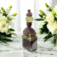 Vintage Romanian art glass perfume bottle with a plum and yellow frosted body, square base, and rounded neck, adorned with bronze wire and a sculptural stopper featuring a translucent yellow-green bead and plum-toned top.
