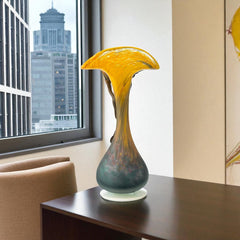 Vintage Romanian art glass vase from the 1990s featuring a frosted teal base, vibrant yellow flared top, and sculptural bronze overlay. Signed by the artist near the base. Elegant and expressive, with subtle surface variation and rich color contrast.
