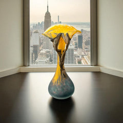Vintage Romanian art glass vase from the 1990s featuring a frosted teal base, vibrant yellow flared top, and sculptural bronze overlay. Signed by the artist near the base. Elegant and expressive, with subtle surface variation and rich color contrast.