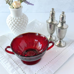 Vintage ruby red double‑handled footed glass bowls with paneled design and subtle amber rim, shown in natural light for color and detail.