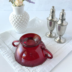 Vintage ruby red double‑handled footed glass bowls with paneled design and subtle amber rim, shown in natural light for color and detail.