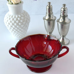 Vintage ruby red double‑handled footed glass bowls with paneled design and subtle amber rim, shown in natural light for color and detail.