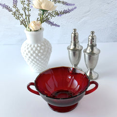 Vintage ruby red double‑handled footed glass bowls with paneled design and subtle amber rim, shown in natural light for color and detail.