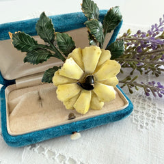 Vintage Sandor yellow enamel flower brooch with green leaves and gold tone accents.