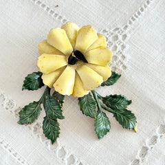 Vintage Sandor yellow enamel flower brooch with green leaves and gold tone accents.
