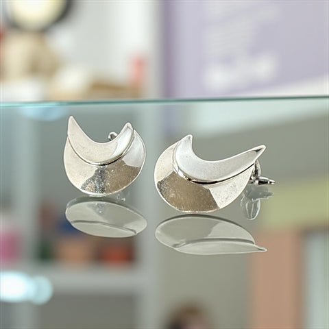 Vintage Sarah Coventry clip-on earrings with shiny silver-tone abstract crescent design; signed on back with copyright symbol, mid-century modernist style in very good condition.
