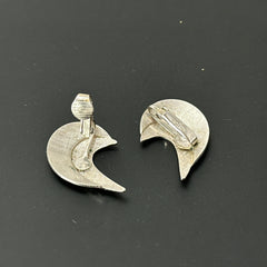Vintage Sarah Coventry clip-on earrings with shiny silver-tone abstract crescent design; signed on back with copyright symbol, mid-century modernist style in very good condition.