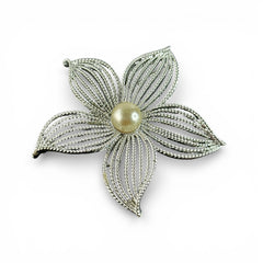 Vintage 1967 Sarah Coventry ‘Moon Flower’ brooch with silver‑tone openwork petals and a central faux pearl, shown in close detail to highlight its sculptural mid‑century design.