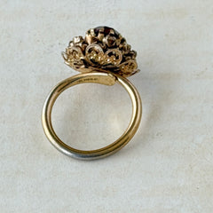Vintage gold‑tone Sarah Coventry ring with red rhinestones in a raised floral cluster design, adjustable band, signed Sarah Cov.
