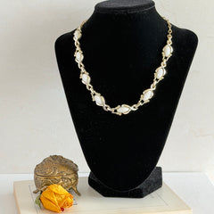 Vintage Sarah Coventry necklace with white ribbed thermoset panels, clear rhinestones, and gold‑tone links, shown from multiple angles to display its mid‑century design.