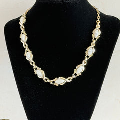Vintage Sarah Coventry necklace with white ribbed thermoset panels, clear rhinestones, and gold‑tone links, shown from multiple angles to display its mid‑century design.