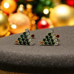 Pair of vintage Sarah Coventry clip-on earrings shaped like Christmas trees, featuring clear and green rhinestones as leaves, a red rhinestone trunk, and a yellow rhinestone star at the top. Gold tone metal with signed clips. Small size, festive design.