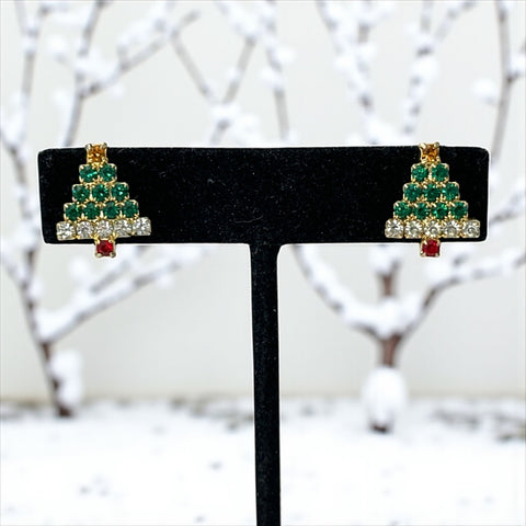 Pair of vintage Sarah Coventry clip-on earrings shaped like Christmas trees, featuring clear and green rhinestones as leaves, a red rhinestone trunk, and a yellow rhinestone star at the top. Gold tone metal with signed clips. Small size, festive design.