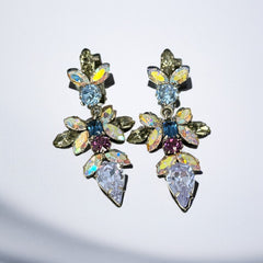 Vintage Schoffel Austria dangle earrings featuring blue, purple, and aurora borealis crystals in silver-tone settings, with floral and teardrop motifs, shown from multiple angles to highlight sparkle, craftsmanship, and signed crown mark.