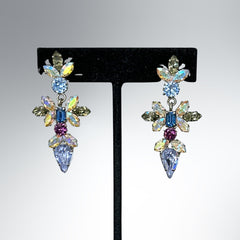 Vintage Schoffel Austria dangle earrings featuring blue, purple, and aurora borealis crystals in silver-tone settings, with floral and teardrop motifs, shown from multiple angles to highlight sparkle, craftsmanship, and signed crown mark.