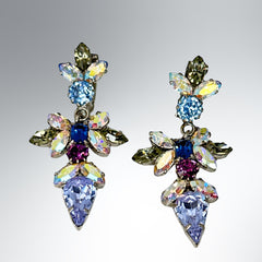 Vintage Schoffel Austria dangle earrings featuring blue, purple, and aurora borealis crystals in silver-tone settings, with floral and teardrop motifs, shown from multiple angles to highlight sparkle, craftsmanship, and signed crown mark.