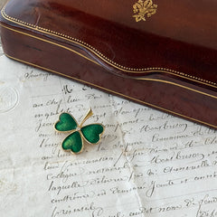 Vintage BJ green enamel shamrock brooch in gold tone with clear rhinestone center, shown in box and on antique French paper.