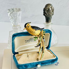 Vintage gold‑tone bird of paradise brooch with navy and green enamel accents, clear pave rhinestones, and a textured metal body, signed Sphinx with model number A2385.
