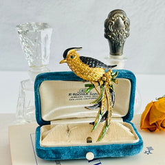 Vintage gold‑tone bird of paradise brooch with navy and green enamel accents, clear pave rhinestones, and a textured metal body, signed Sphinx with model number A2385.
