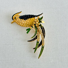Vintage gold‑tone bird of paradise brooch with navy and green enamel accents, clear pave rhinestones, and a textured metal body, signed Sphinx with model number A2385.