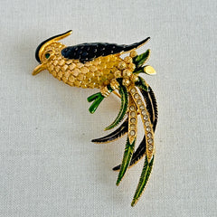 Vintage gold‑tone bird of paradise brooch with navy and green enamel accents, clear pave rhinestones, and a textured metal body, signed Sphinx with model number A2385.
