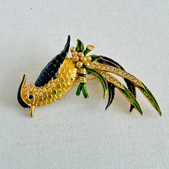Vintage gold‑tone bird of paradise brooch with navy and green enamel accents, clear pave rhinestones, and a textured metal body, signed Sphinx with model number A2385.
