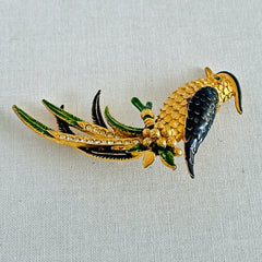 Vintage gold‑tone bird of paradise brooch with navy and green enamel accents, clear pave rhinestones, and a textured metal body, signed Sphinx with model number A2385.